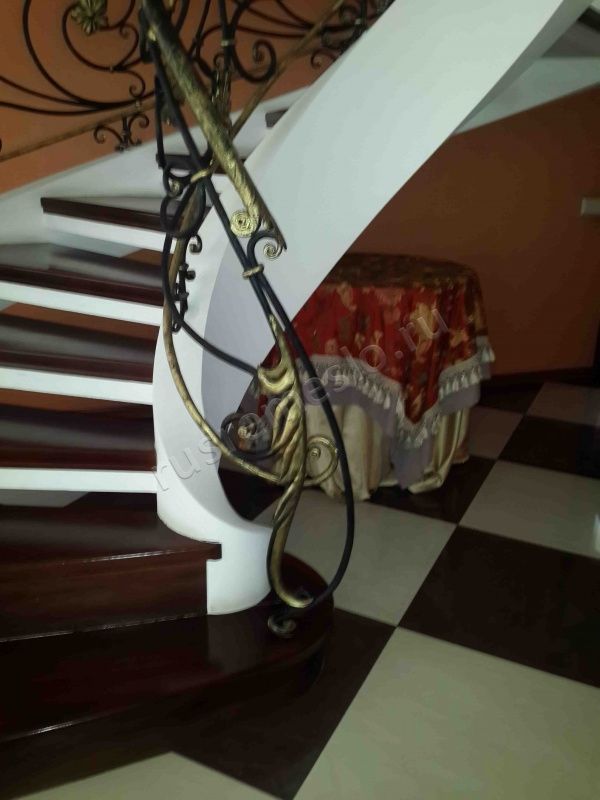 Винтовая лестница из массива дуба с кованными перилами